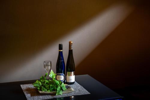 two bottles of wine and glasses on a table at Musubi in Nabari