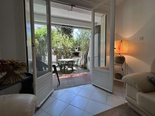 - un salon avec une porte s'ouvrant sur une terrasse dans l'établissement Appartement 2 Ch, 6 Pers, Clim, Près Plage à Saint-Pierre-La-Mer - FR-1-229D-165, à Fleury