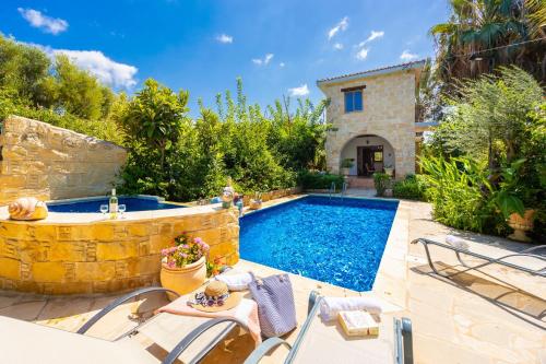 a villa with a swimming pool and a house at Villa Angela Paradise in Argaka
