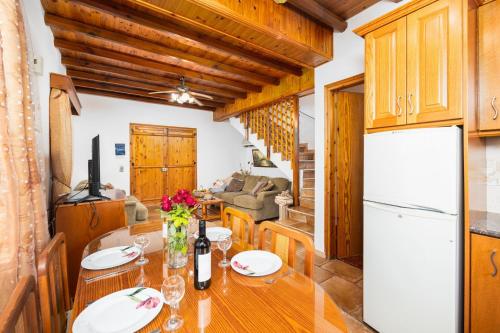 a kitchen and dining room with a table and a refrigerator at Villa Angela Paradise in Argaka