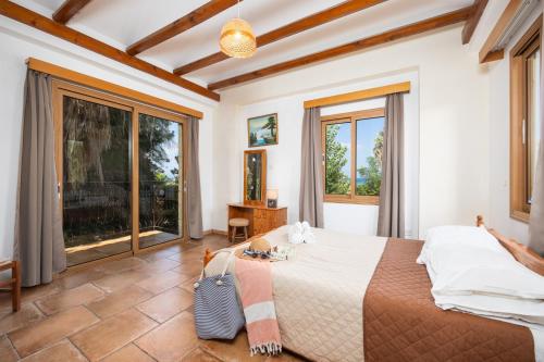 a bedroom with a large bed and large windows at Villa Angela Paradise in Argaka