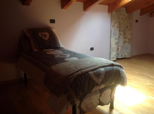 um quarto com uma cama com uma colcha em Matt Home em Verrès