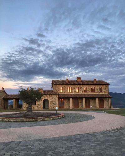 a large building with a tree in front of it at Catignano A6 - Modern unit, scenic Volterra hills in Mazzolla
