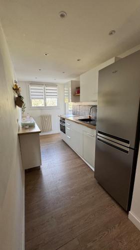 une cuisine avec un réfrigérateur en acier inoxydable et du parquet dans l'établissement Le Parfum de Grasse, à Grasse