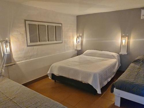 een slaapkamer met 2 bedden en 2 verlichting aan de muur bij Quinti in La Rioja