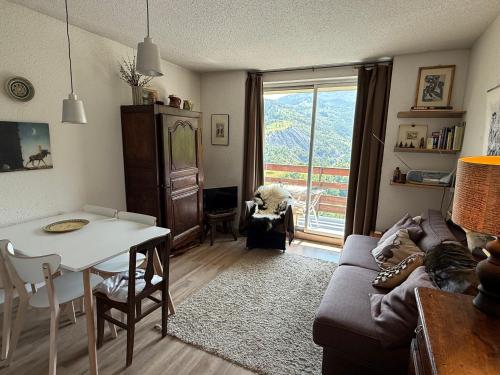 un salon avec une table et un canapé dans l'établissement T2 au coeur du Sauze, à Enchastrayes
