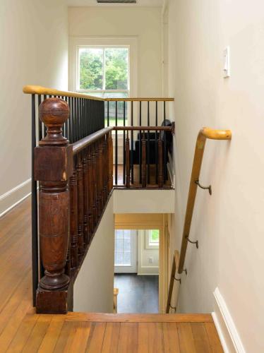 a wooden spiral staircase in a house with a window at Station Inn Pawling in Pawling