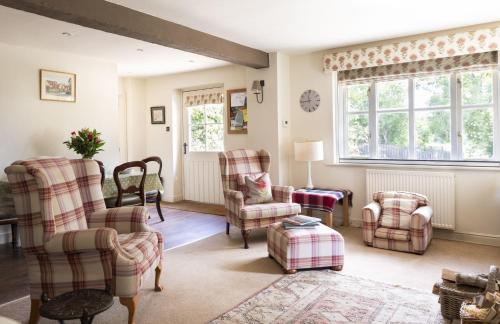 a living room with chairs and a table at Anvil Cottage in Grewelthorpe