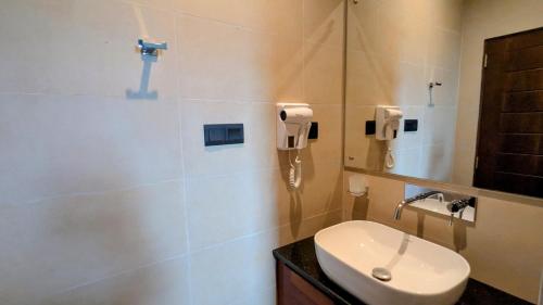 a bathroom with a toilet and a sink and a phone at Royal Lion Hotel - Kandy Road, Galagadara in Galagedara
