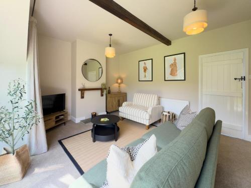 a living room with a couch and a tv at Farmhouse Feels & Peak Views in Pott Shrigley