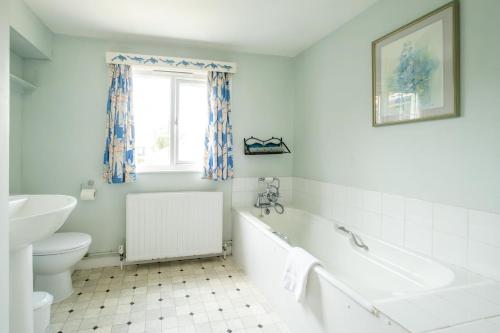 a bathroom with a tub and a toilet and a sink at Sea View, Thorpeness in Thorpeness