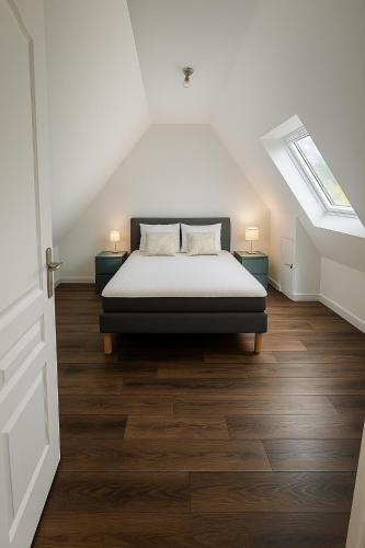 une chambre avec un lit dans un grenier dans l'établissement Pen Bizien, à Ploëzal