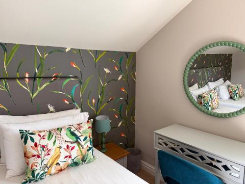 a bedroom with a bed and a mirror at Brantwood Cottage in Keldhead