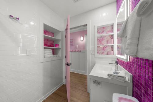 a bathroom with pink and white walls and a sink at Pink Prerogative Beach Bungalow with Private Pool in Panama City Beach