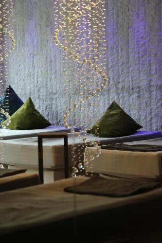 two beds with pillows in a room with lights at Gartenhotel Moser in Appiano sulla Strada del Vino