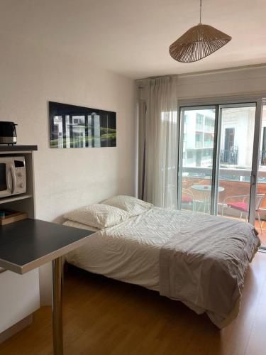 une chambre avec un lit, une table et une fenêtre dans l'établissement Studio 25 m2 Vendôme au cœur d'Aix-Les-Bains, balcon, à Aix-les-Bains