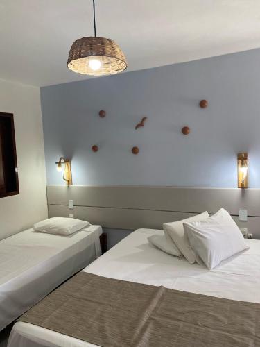 two beds in a room with a blue wall at Pousada Vivenda Oriente in São José da Coroa Grande