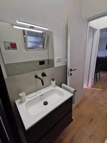 a bathroom with a white sink and a mirror at Cuore Rosso in Chiavari