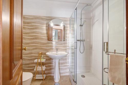 un baño con lavabo y ducha en Casa Abelha, en Armação de Pêra
