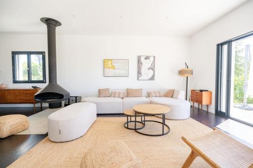 un salon avec un canapé blanc et une cheminée dans l'établissement Magnifique Villa à 5 minutes d'Aix, à Aix-en-Provence