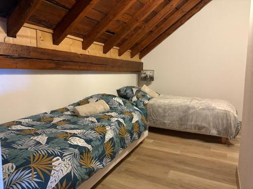 - une chambre avec un lit et un couvre-lit dans l'établissement Chaleureux Duplex - Ski & Rando, à Samoëns