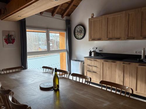 - une cuisine avec une table et une bouteille de vin dans l'établissement Chaleureux Duplex - Ski & Rando, à Samoëns