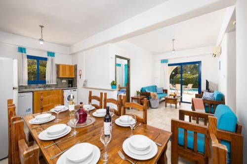 a kitchen and dining room with a wooden table and chairs at Villa Artemis in Peyia