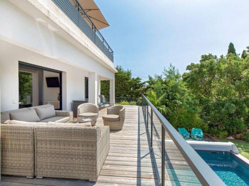 - une terrasse avec un canapé et des chaises à côté de la piscine dans l'établissement Villa Contemporaine avec Piscine et Climatisation à St Aygulf - FR-1-768-113, à Fréjus