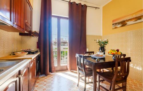 a kitchen with a table with chairs and a window at La Rosa Dei Venti in Villanova di Ostuni