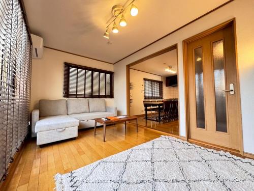a living room with a couch and a table at スリーチアーズ in Okayama