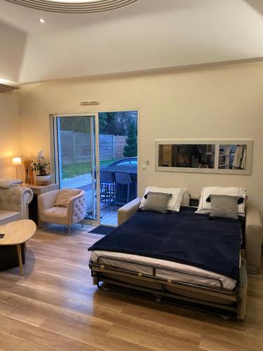 une chambre avec un lit et un salon dans l'établissement Maison - villa avec piscine proche commerce et transports en commun, à Couëron