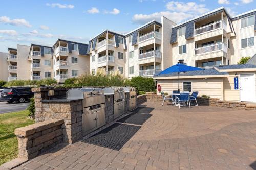 a patio with an outdoor grill in front of a building at A Place at the Beach III in Atlantic Beach