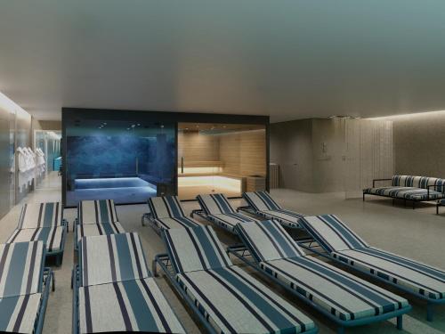 a group of lounge chairs in a room with a bedroom at Novotel Malta Sliema in Il-Gżira