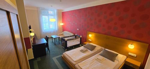 a hotel room with a bed and a chair at Hotel Vacek Pod Věží in Hradec Králové