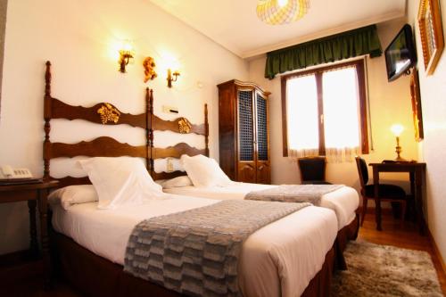a hotel room with two beds and a window at Hotel Merindad de Olite in Olite