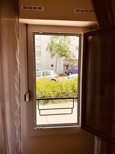 a window in a room with a view of a street at Grand T2 tout confort 48 M2 - Offre cinéma et sport canal séries, netflix, Dazen, eurosport, apple TV, OCS, paramount, prime vidéo in Nancy