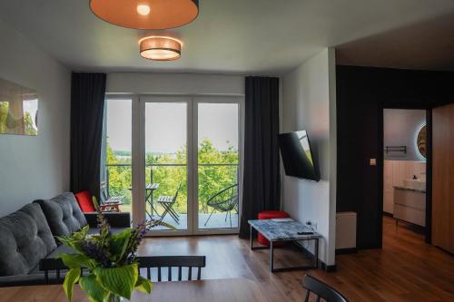 un soggiorno con un divano e una grande finestra di Moje Miejsce Polanica-Zdrój a Polanica-Zdrój