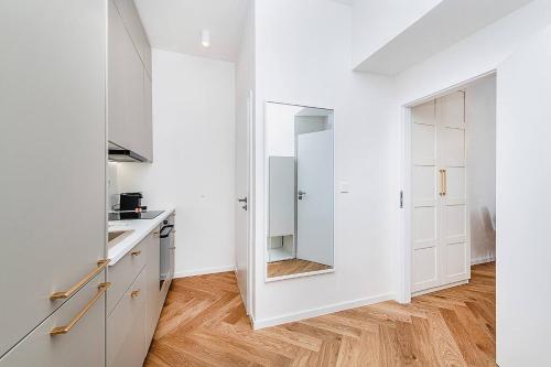 - une cuisine avec des placards blancs et un grand miroir dans l'établissement Rudi Gare Perrache Ckeck in H24 WIFI, à Lyon