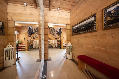 a room with wood paneling and a wall with paintings at Domek, Apartamenty i pokoje Willa Elita in Kościelisko