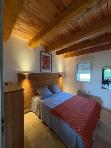 une chambre avec un grand lit avec une tête de lit en bois dans l'établissement Villa Evanine, à Saint-Privat-de-Champclos