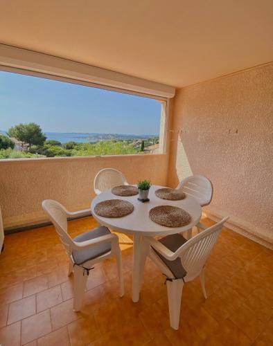 une table et des chaises dans une pièce avec une grande fenêtre dans l'établissement Lovely studio with sea view, à Sainte-Maxime