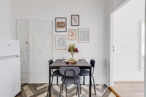 a dining room with a black table and chairs at Suite Joka Part Dieu Wifi Check in H24 in Fourvière