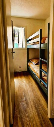 une chambre avec deux lits superposés et une fenêtre dans l'établissement Villa Sous les Pins, au Cap d'Agde