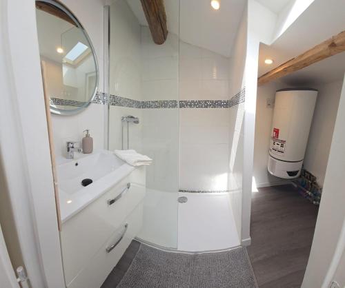 une salle de bain blanche avec une douche et un lavabo dans l'établissement 3P Cozy Movie Room Historic Heart of Clermont, à Clermont-lʼHérault