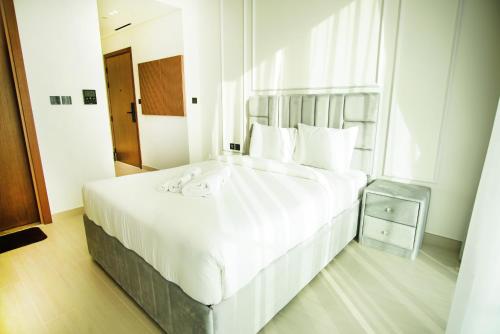 a bedroom with a large white bed and a window at Brand New Studio In Tulip JVC in Dubai