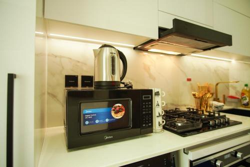 a microwave sitting on top of a stove in a kitchen at Brand New Studio In Tulip JVC in Dubai