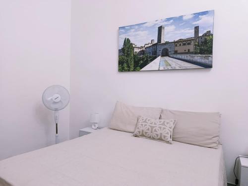 a bedroom with a white bed and a painting on the wall at Nobile Dimora - Centro Storico Ascoli Piceno in Ascoli Piceno