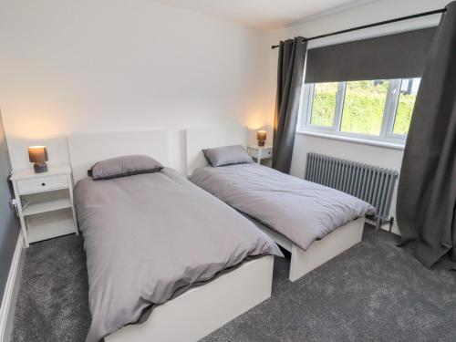 deux lits dans une chambre avec une fenêtre dans l'établissement Rose Cottage, à Alnwick