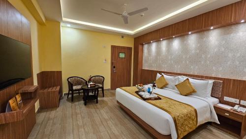 a hotel room with a bed and a television at The Royal Bihar in Patna