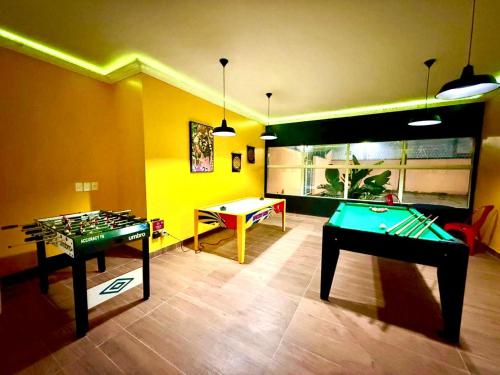 a room with a ping pong table and a pool table at Carlton Plaza Baobá in Taubaté